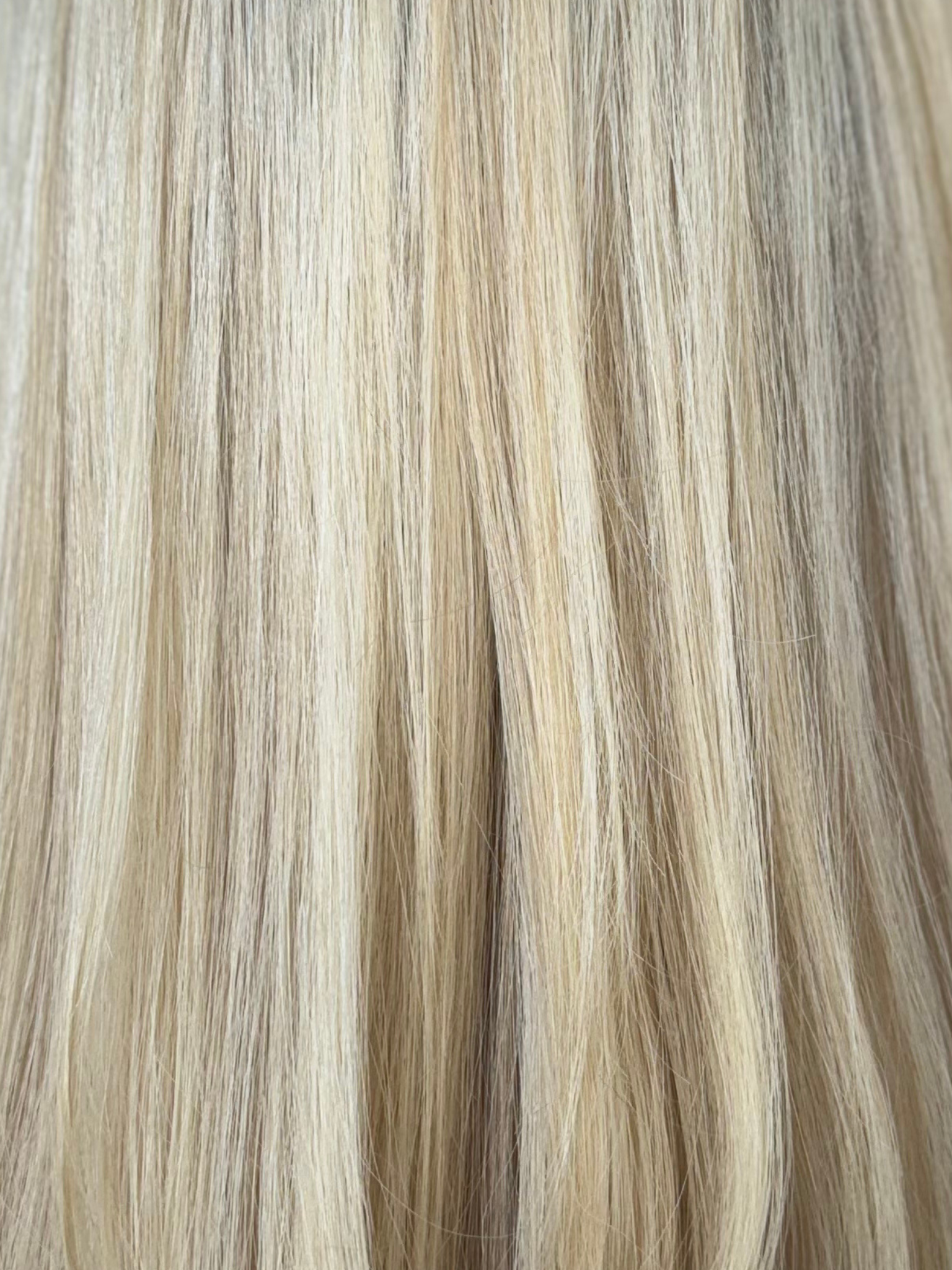 Close-up of blonde hair with a gradient from light to dark.