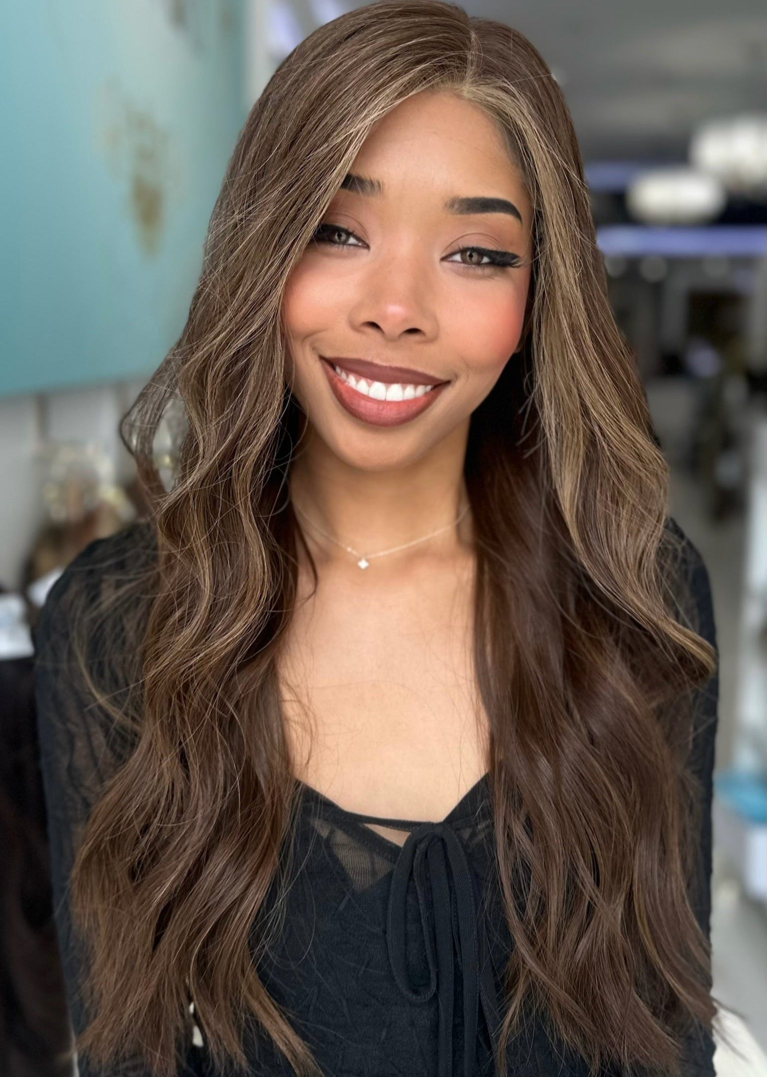 Model wearing Sasha 26-inch long human hair wig in rich espresso brown with chestnut highlights, styled in soft waves