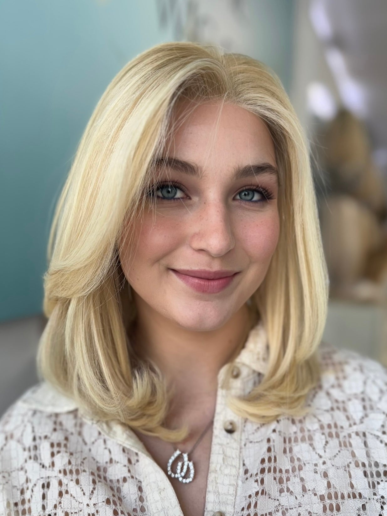 Clara lace top wig, 18 inches in blonde with darker roots, styled in soft waves for a flawless, natural look with pre-cut lace for easy wear.