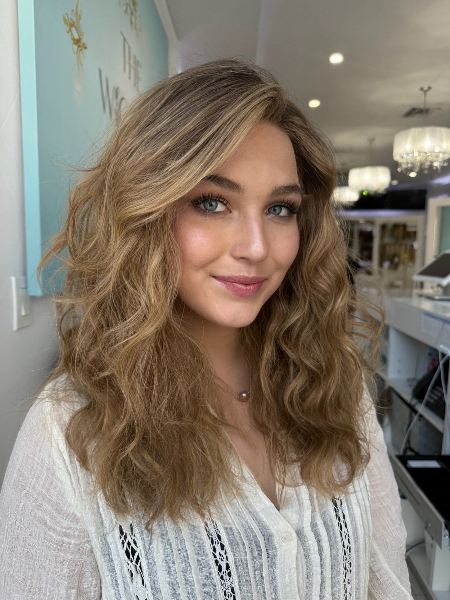 Dawn 22-inch lace top wig in dirty blonde, featuring voluminous waves that flow naturally, with flawless lace for a seamless, polished finish.