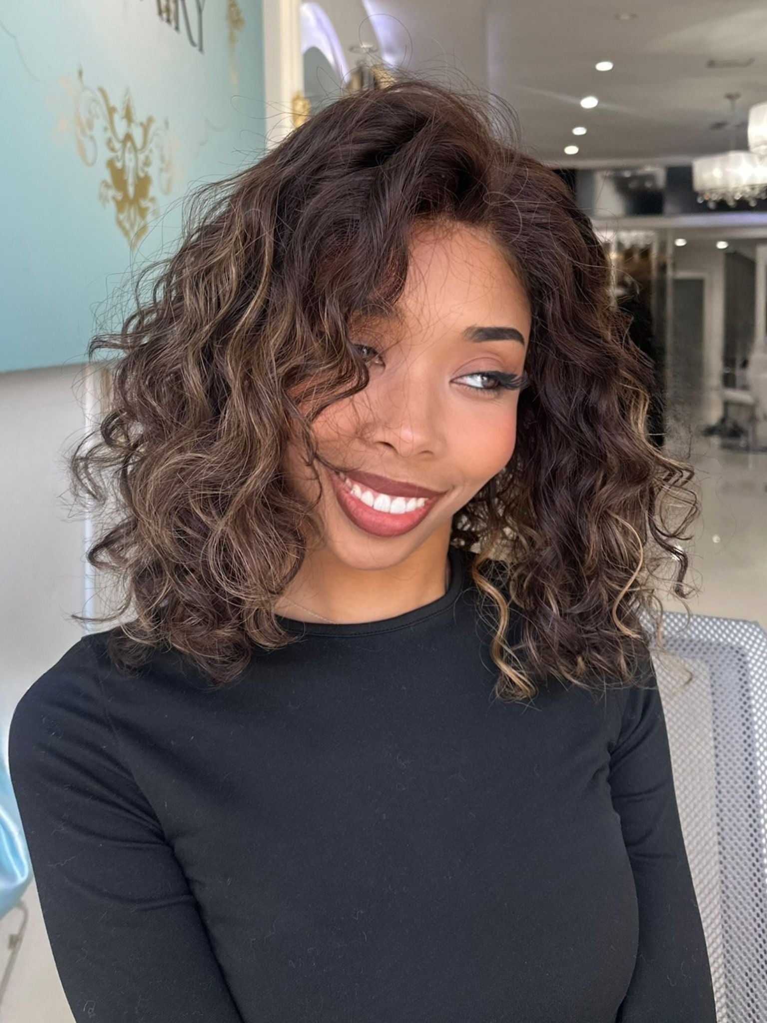 Marissa 17-inch natural dark brown curly human hair wig styled on woman indoors