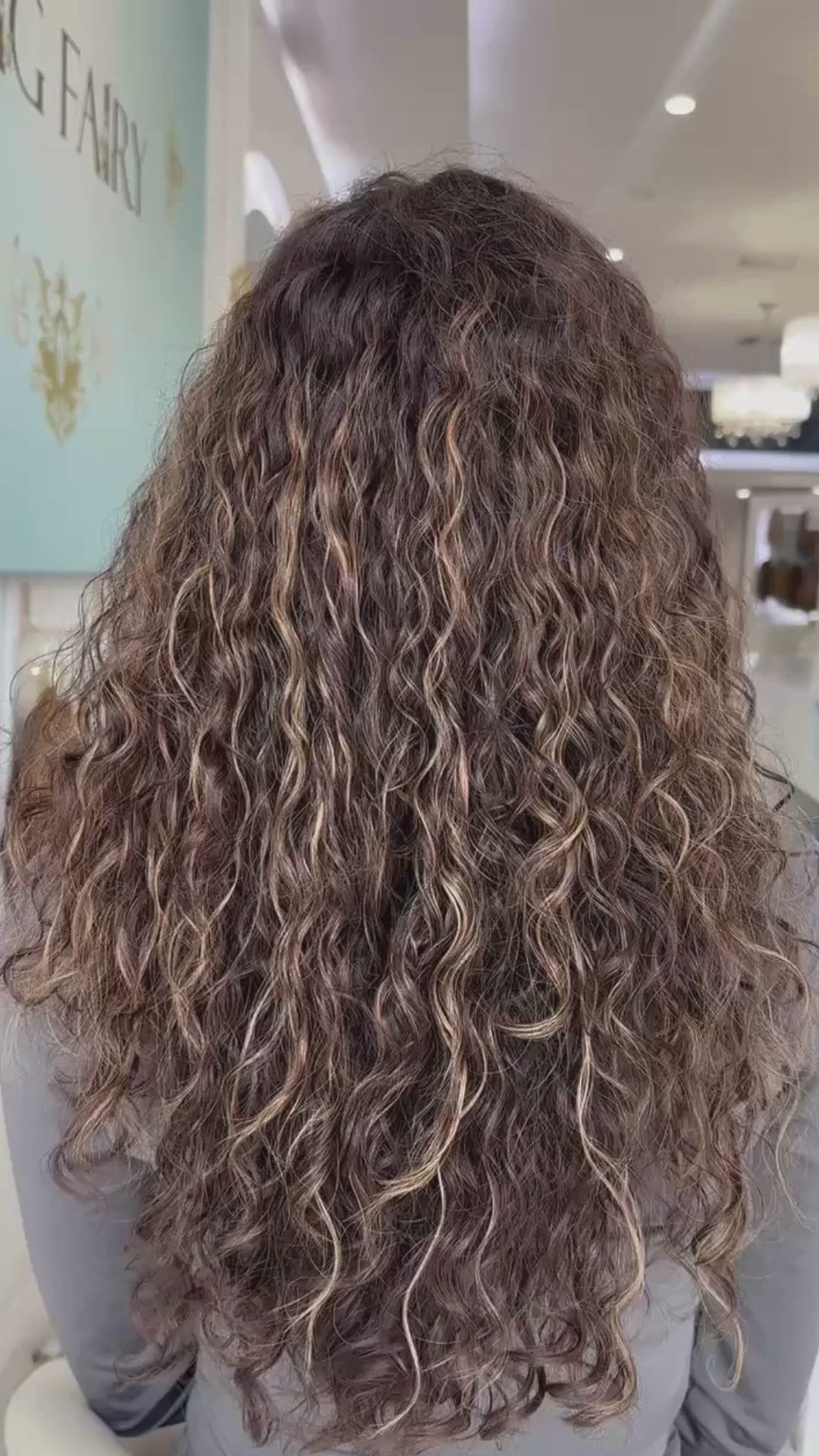 Video of a long, naturally curly brown wig, showcasing defined curls, rich color, and realistic movement.