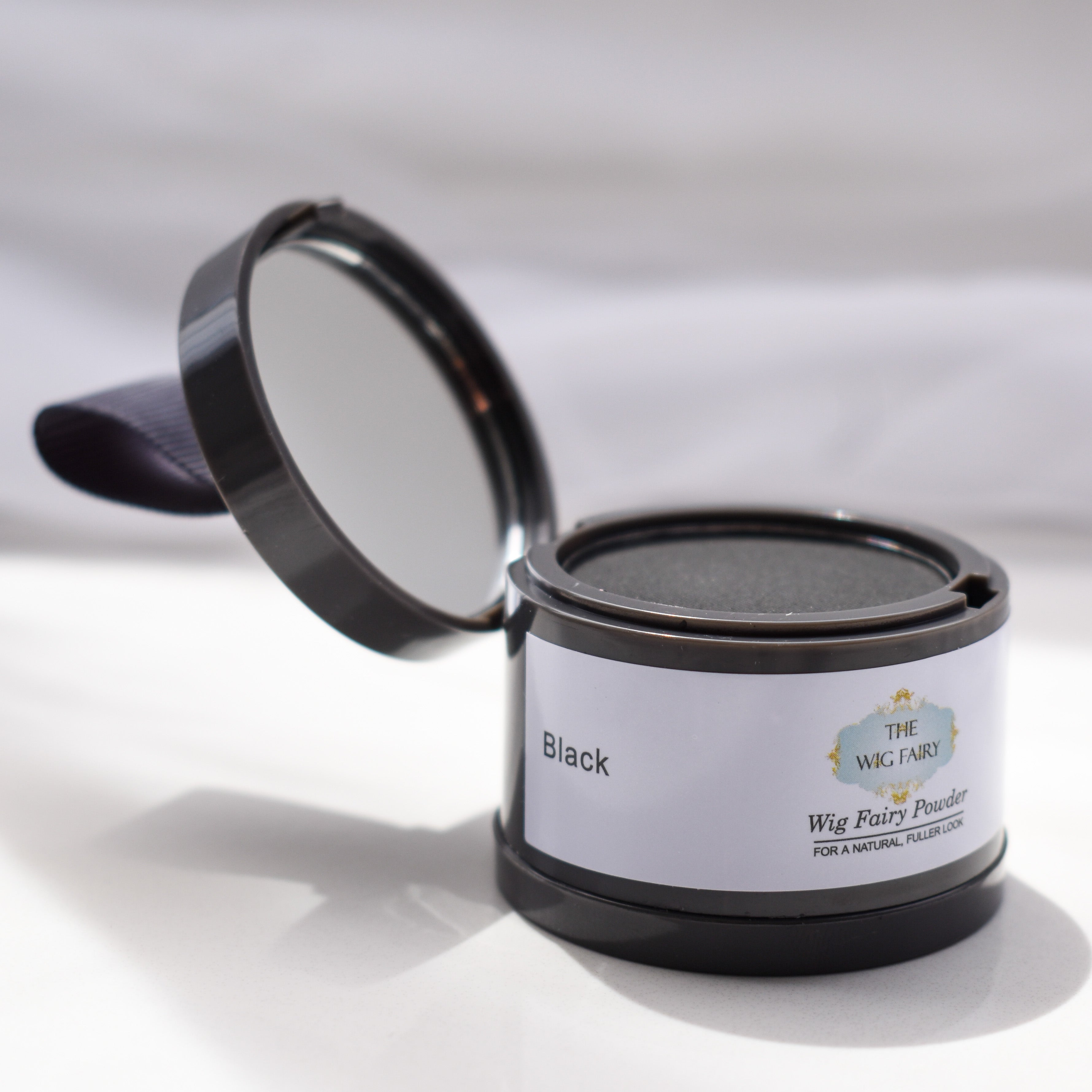 Open Wig Fairy Powder in Black packaging with sponge applicator for temporary wig coverage and scalp blending.