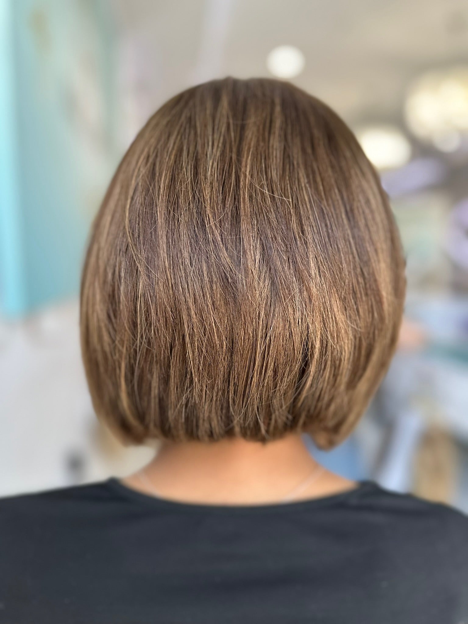 Back view of the Davina wig showing the natural shoulder-length cut and subtle brown-blonde blend.