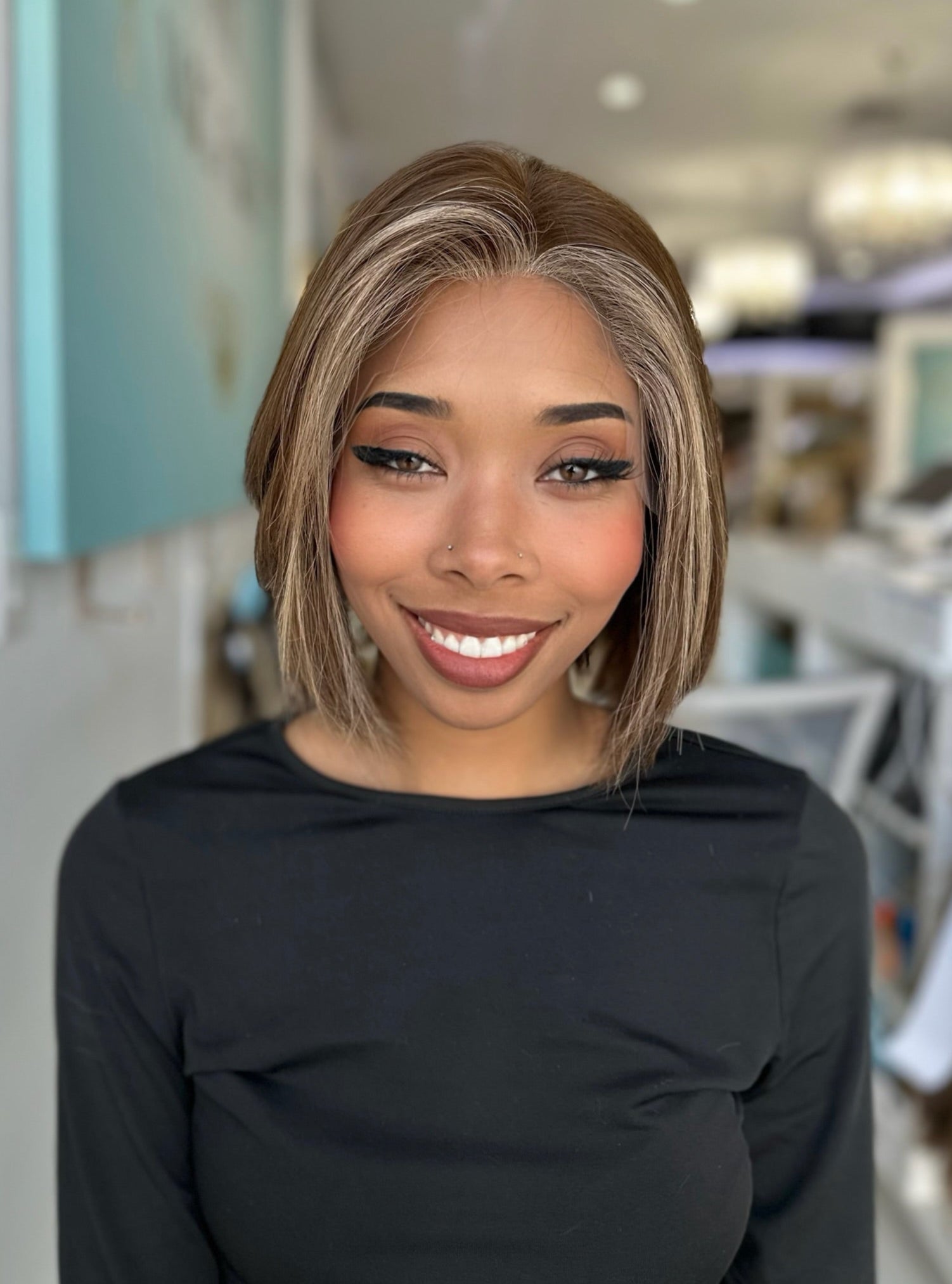 Model wearing the Davina wig from the front, 13 inches in length with warm chocolate brown tones and golden highlights.