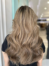 Back view of model wearing a 20-inch lace top wig in warm honey brown with beige blonde highlights, styled in loose waves for a voluminous, natural finish.