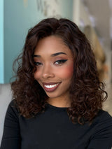 Angled view of Leilani wig, 20-inch curly human hair in espresso brown with subtle highlights, crafted by Beverly Hills stylists.