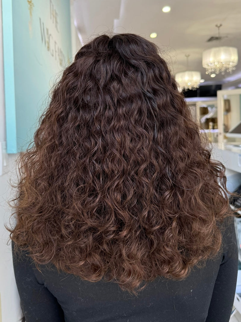 Back view of Leilani 20-inch curly wig in espresso brown with soft highlights, showing expert styling from The Wig Fairy in Beverly Hills.