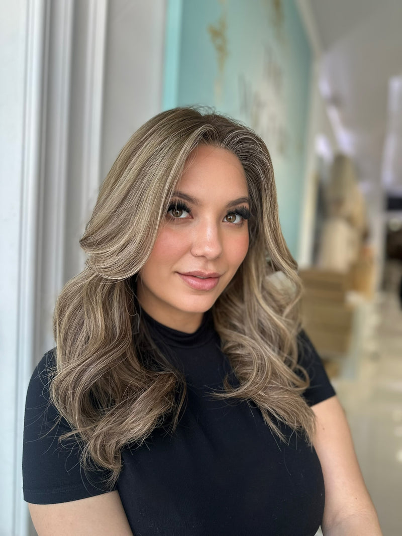 Frontal view of Ashli wig featuring warm honey tones and soft beige blonde highlights, with a natural-looking hairline and pre-cut lace for easy wear.