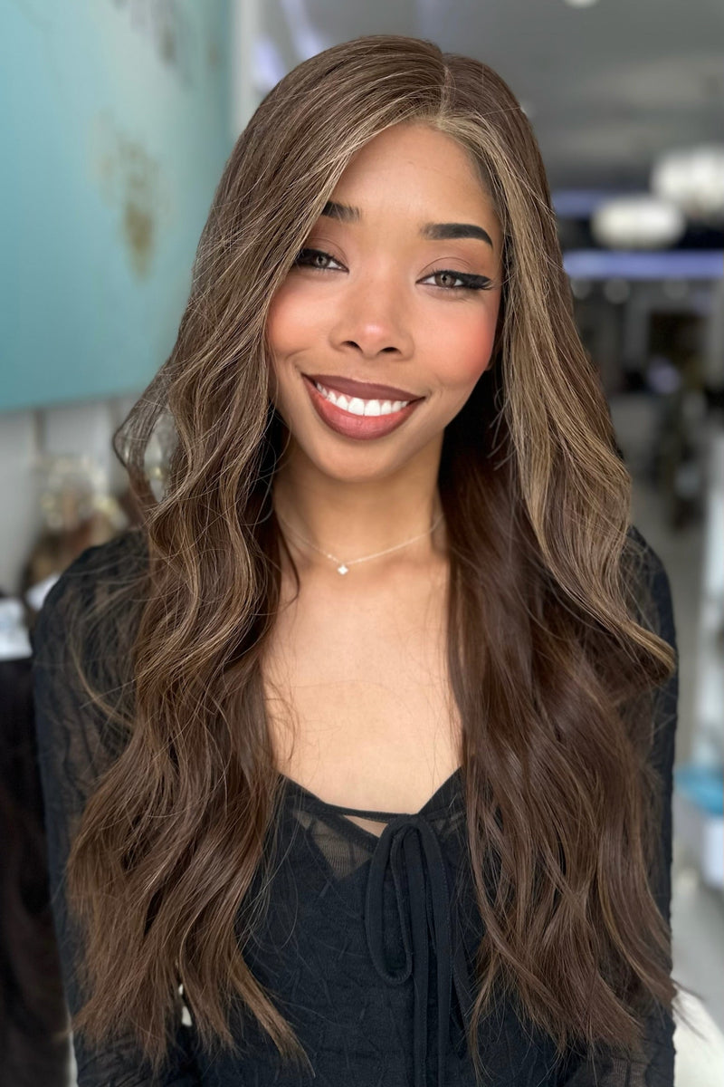 Model wearing Sasha 26-inch long human hair wig in rich espresso brown with chestnut highlights, styled in soft waves