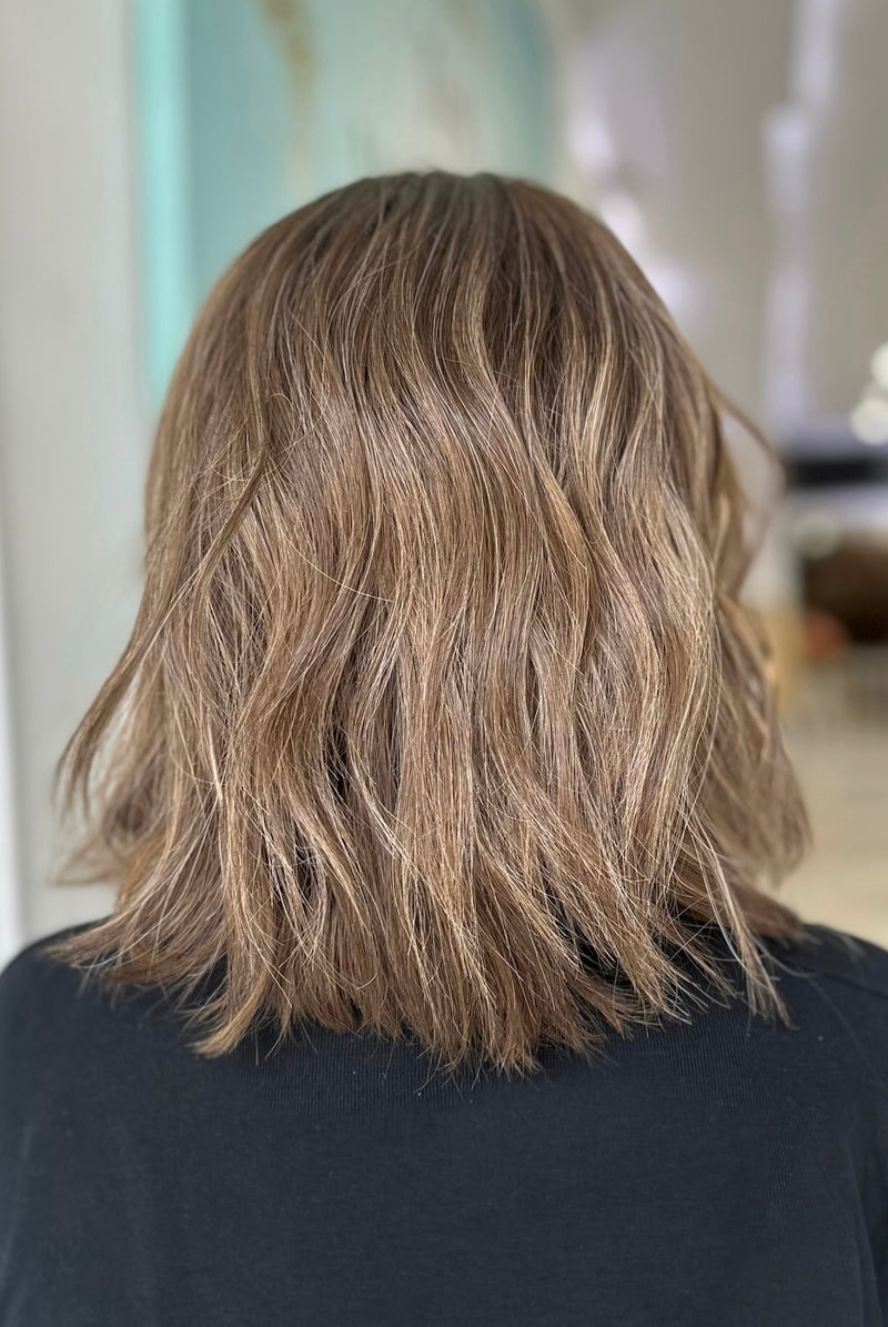 Back view of Camila wig with 15-inch tousled waves in a dark chocolate, ash brown, and sandy blonde blend