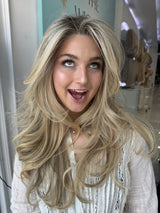  Candice lace top wig, 26 inches in blonde, with pre-cut lace for a flawless, natural look, styled in glamorous, voluminous waves.