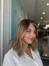 Lace top human hair wig styled in soft waves with dimensional ombré color blend