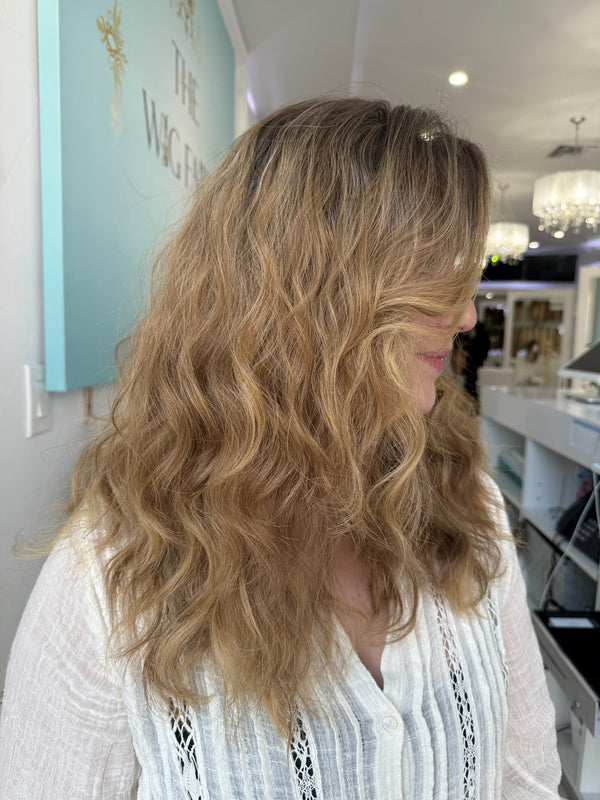 Dawn lace top wig, 22 inches in dirty blonde, with pre-cut lace for a flawless, natural look, styled in beautiful, flowing waves.