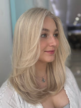 Eliza 23-inch lace top wig in platinum blonde, featuring sleek, smooth waves and flawless lace for a natural, seamless finish.