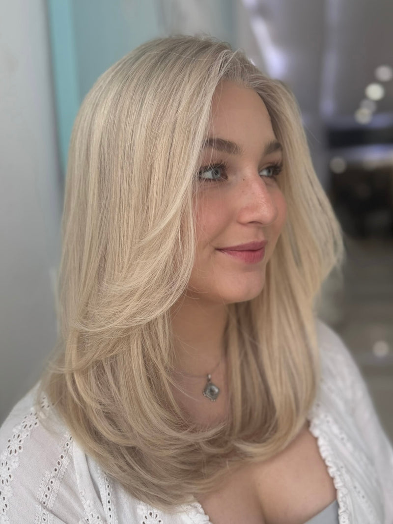 Eliza 23-inch lace top wig in platinum blonde, featuring sleek, smooth waves and flawless lace for a natural, seamless finish.