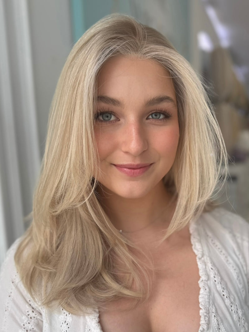 Eliza lace top wig, 23 inches in platinum blonde, styled in soft waves for a flawless, natural look with pre-cut lace for easy wear.
