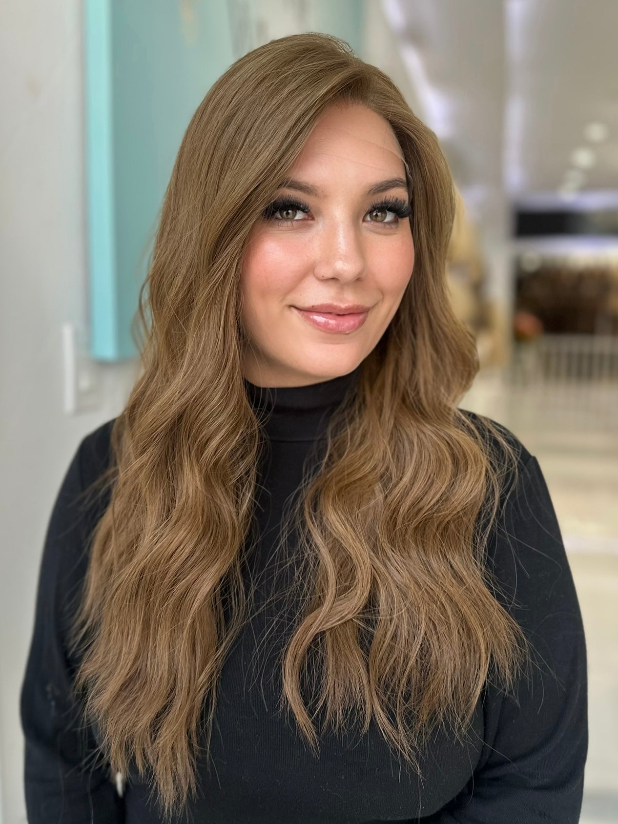 Front view of Erika wig in medium ash brown, pre-cut lace top and soft wavy style, 26-inch length