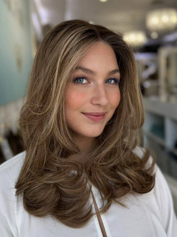 Front view of the Georgia wig in a warm medium brown with soft caramel highlights, 20 inches long, featuring a pre-cut lace for a natural hairline.