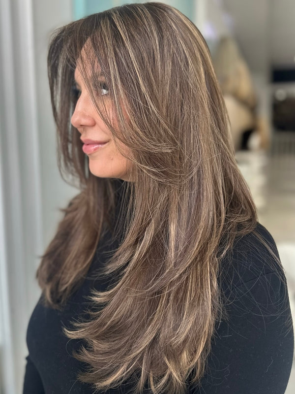 Side view of Gracie wig in chestnut brown with golden blonde highlights, 22-inch layered cut with face-framing pieces and Skin Top