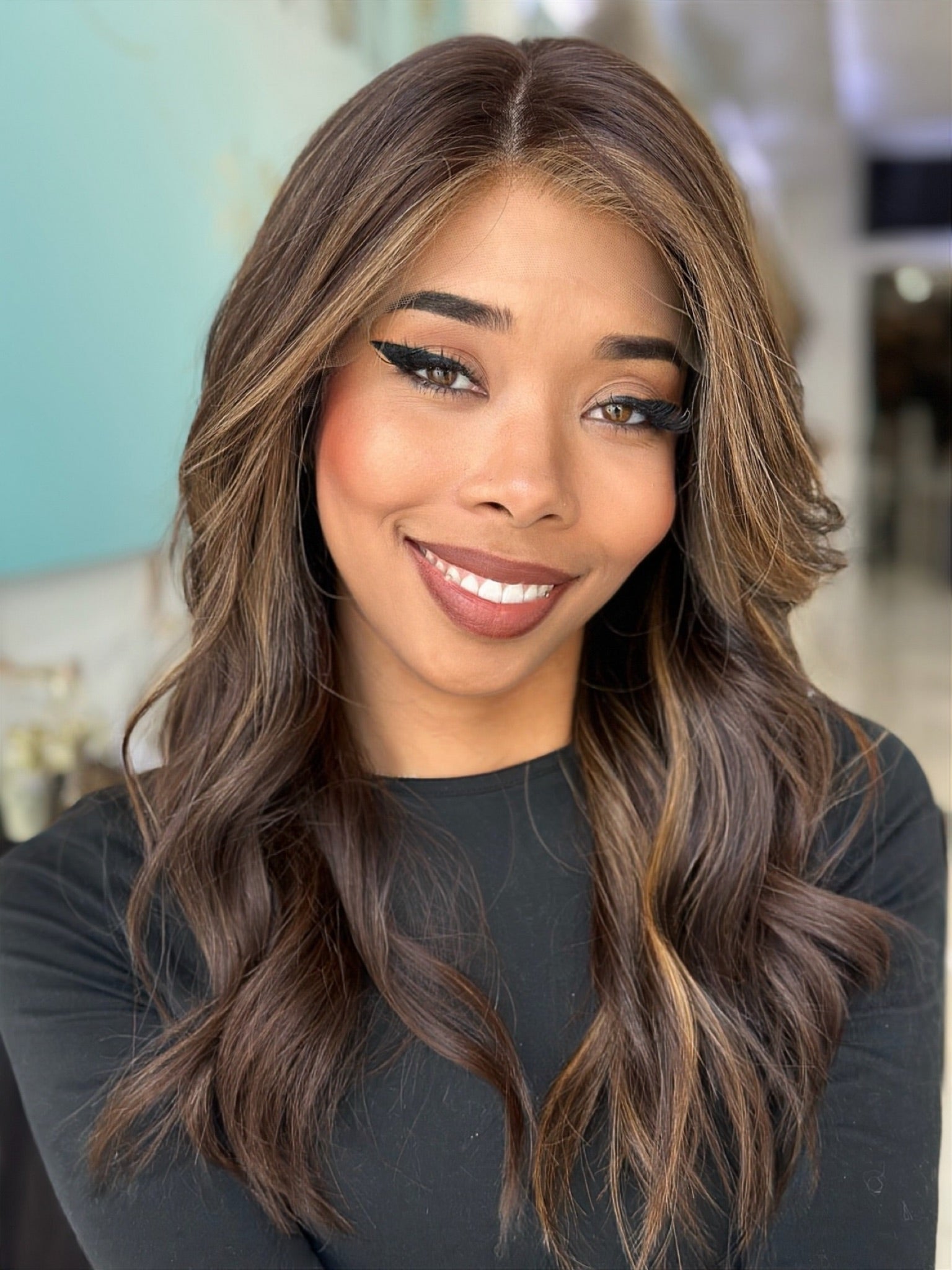 Jada 22-inch lace top wig in brown with caramel highlights, featuring voluminous waves and flawless lace for a natural, chic finish.