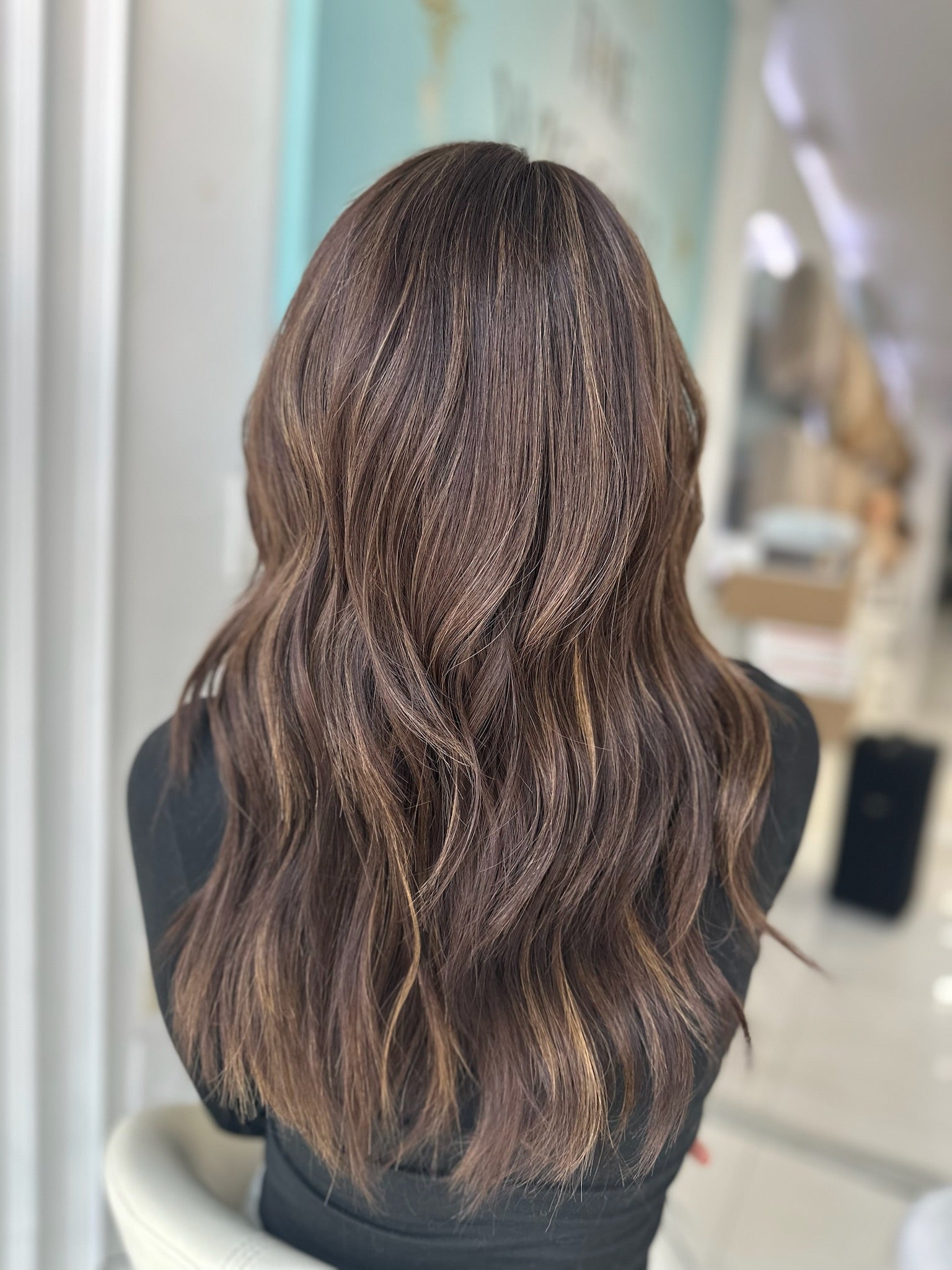 Jada lace top wig, 22 inches in brown with caramel highlights, with pre-cut lace for a flawless, natural look, styled in elegant waves.