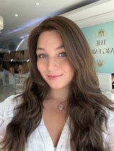 Close-up of brunette human hair wig with naturally wavy texture and skin top detail