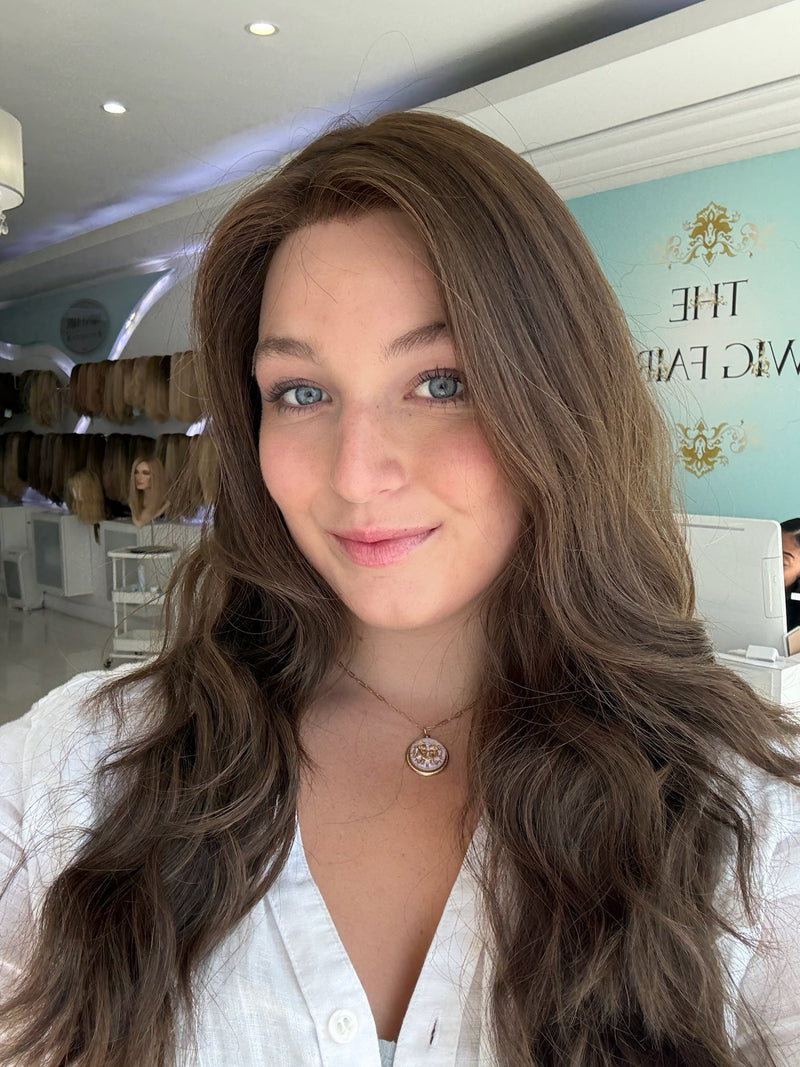 Close-up of brunette human hair wig with naturally wavy texture and skin top detail