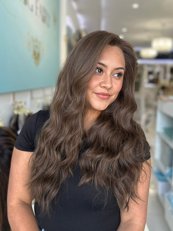 Naturally wavy brunette Brazilian wig in 24 inches with skin top, worn in salon setting