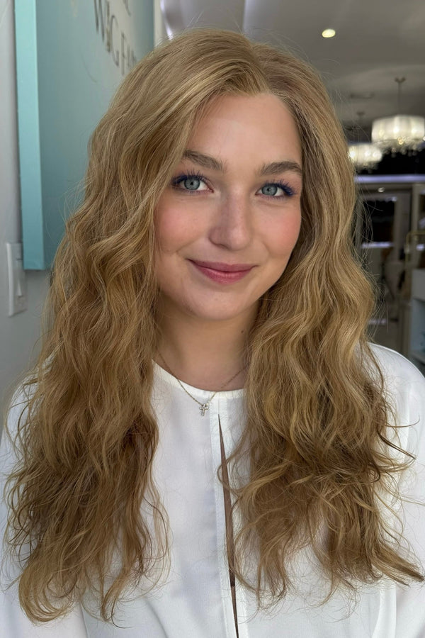 Naturally curly - wavy brown blonde wig with lace front on a confident model
