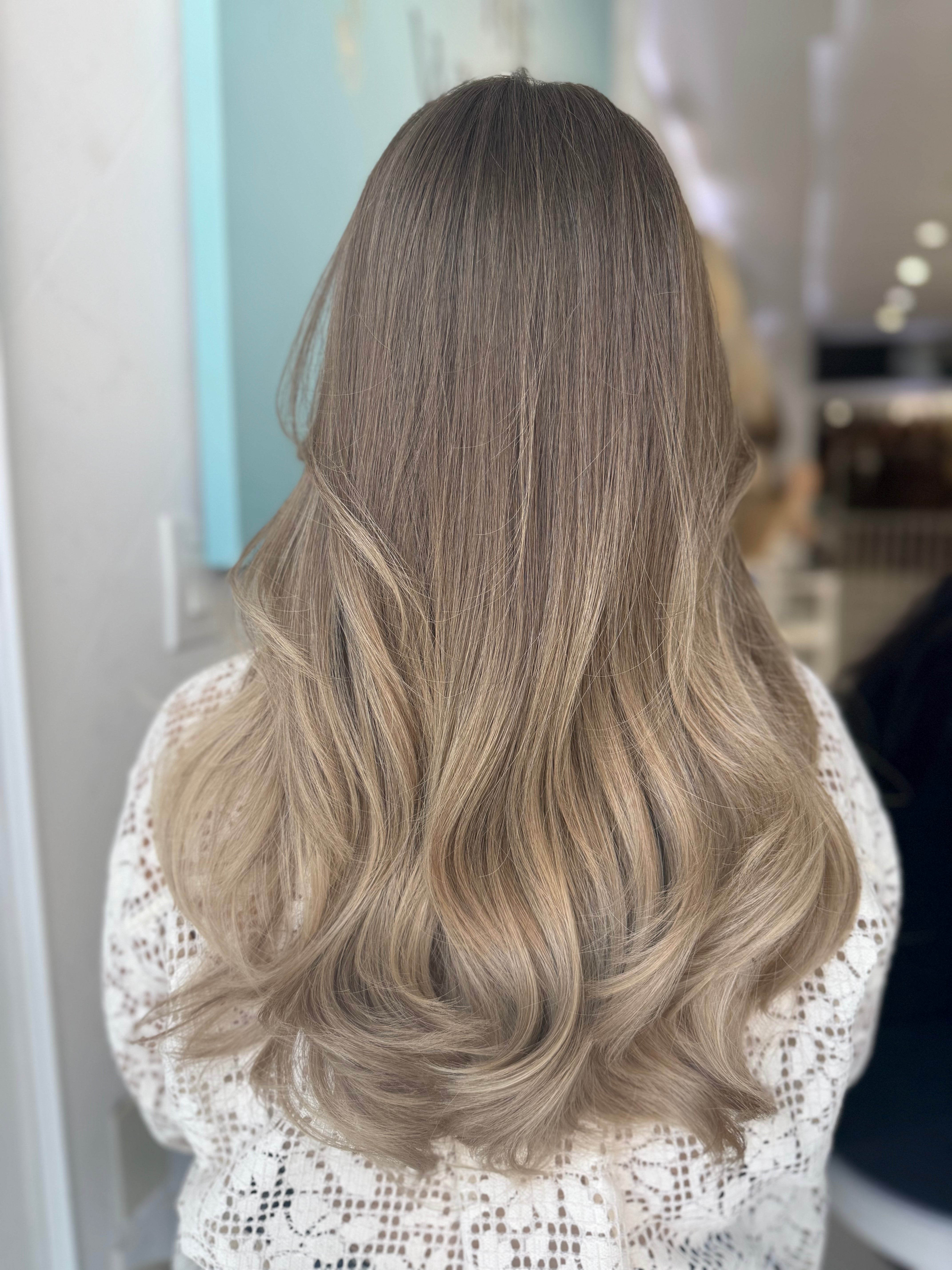 Nora lace top wig, 22 inches in light brown blonde, with pre-cut lace for a seamless, natural look, styled in gentle waves.