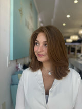 Side view of short human hair wig in red-toned brown with subtle layers and a natural tone
