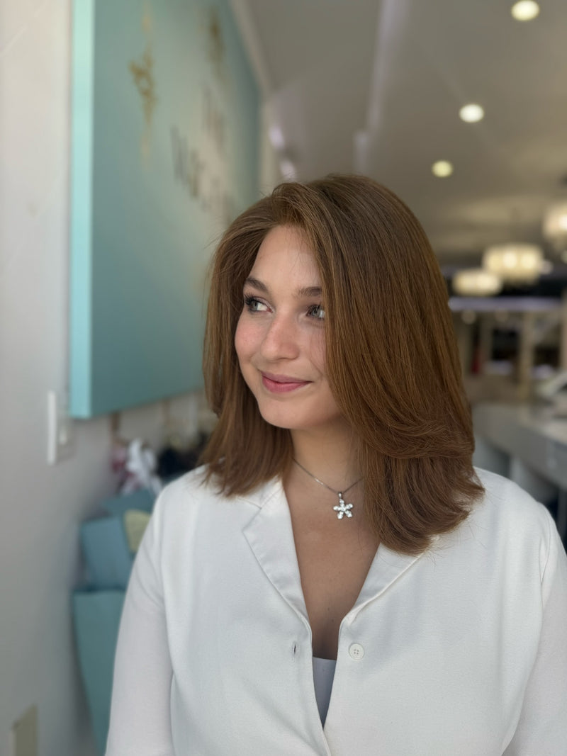 Side view of short human hair wig in red-toned brown with subtle layers and a natural tone