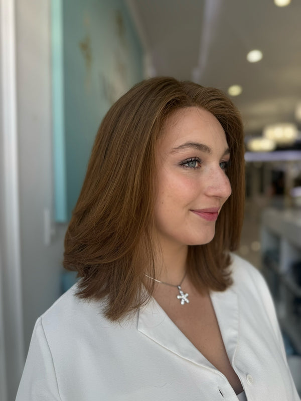Side view of short human hair wig in red-toned brown with subtle layers