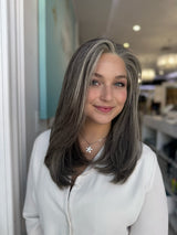 Model wearing Zora 20-inch long silver gray salt and pepper lace front wig