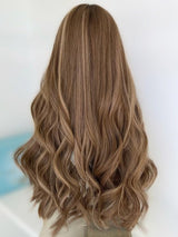 Back view of The Wig Fairy Aliana wig, showcasing soft 26-inch waves in a neutral ash blonde with light caramel undertones and fine highlights.