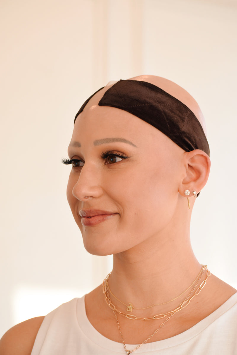 Three-quarter view of model smiling in The Wig Fairy beige wig grip band, showing smooth velvet and secure placement.